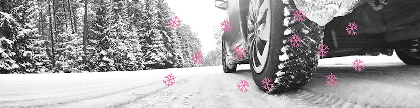 Nahaufnahme eines Winterreifens auf schneebedeckter Straße – Vorteile von Winterreifen
