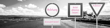 Verkehrsschilder mit pinker Schrift