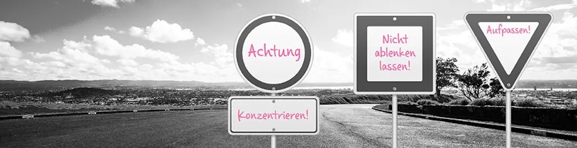 Verkehrsschilder mit pinker Schrift