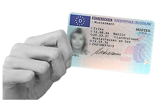 Eine Hand hält einen deutschen Führerschein hoch.
