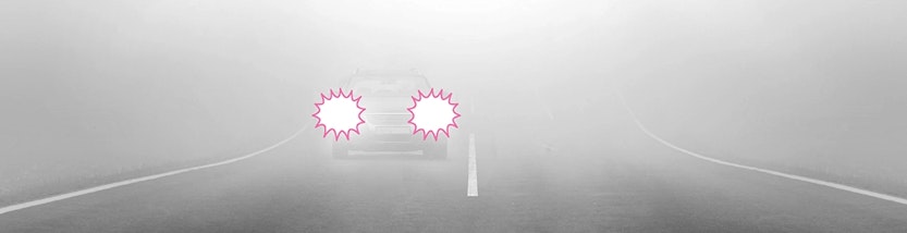 Ein Auto fährt bei Nebel auf einer Straße