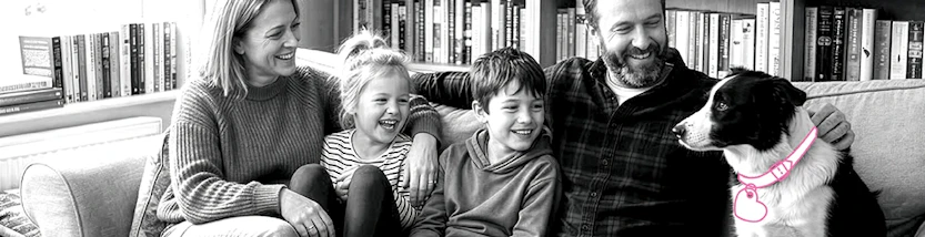 Eine Familie sitzt mit Hund auf dem Sofa