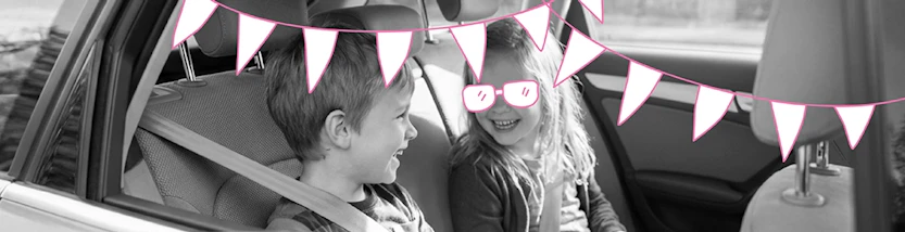 2 Kinder sitzen auf der Rückbank eines Autos und spielen Spiele