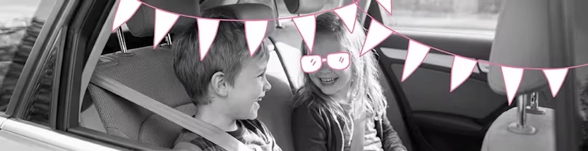 2 Kinder sitzen auf der Rückbank eines Autos und spielen Spiele