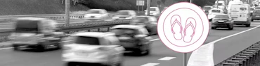 Illustriertes Verkehrsschild mit Flip-Flops an einer befahrenen Straße