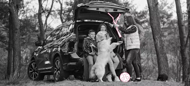 Familie steht hinter dem Auto